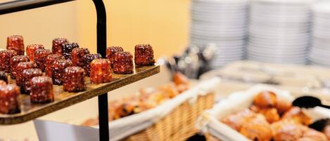 Un bufé con diversas opciones de comida, incluyendo gofres, pasteles y una selección de postres.