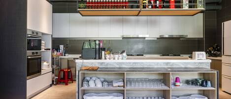 Uma cozinha moderna com eletrodomésticos embutidos, um espaço para café e um suporte para vinhos.
