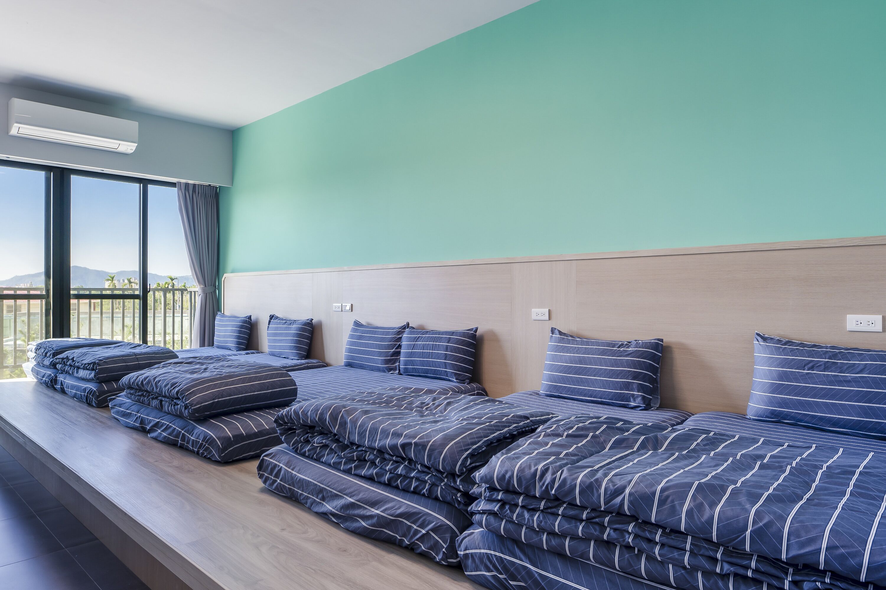 Habitación de hotel con una cama grande, un banco y vistas de la ciudad.