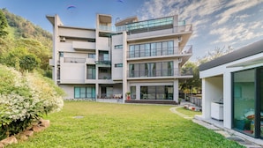 A modern multi-story building with balconies and large windows. - Hills Valleys (Puli)