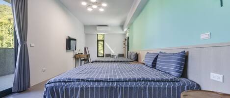 A modern bedroom with a large bed, a bedside table, a desk, and a chair.