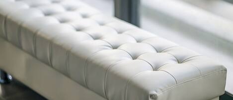 Un banc blanc, doté d’un dossier arrondi et d’une assise lisse et légèrement capitonnée.