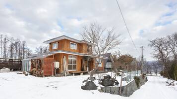 Situated in a serene winter landscape, this cabin features a spacious porch and large windows.