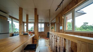 Una cucina moderna con travi in legno, un bancone lungo e vista sull'esterno.