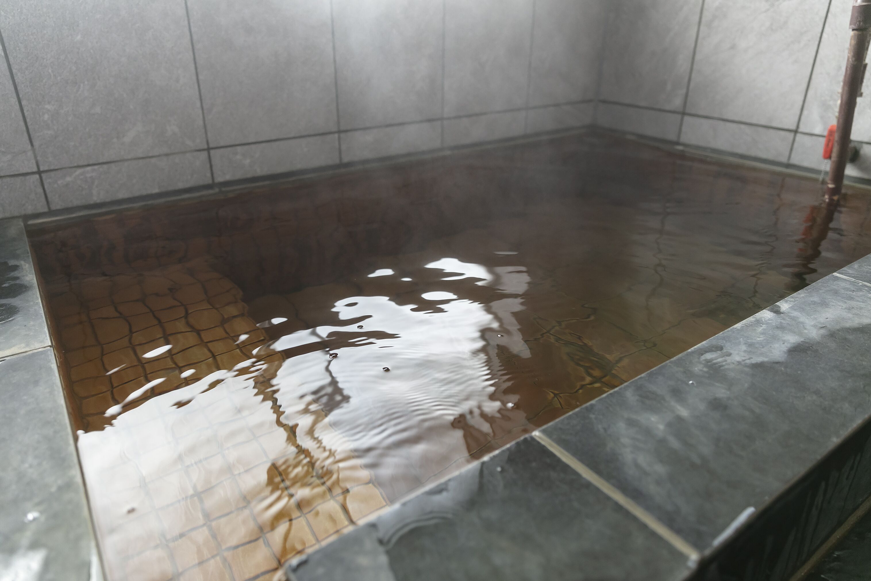 A wet tiled floor with a visible water drain.