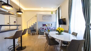 A modern living space with a dining area, kitchen, and staircase. - Bonne Chance Apartments (Zagreb)