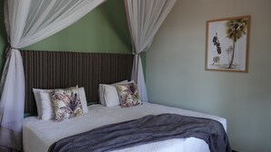 A bed with a canopy, pillows, a blanket, and a wall-mounted air conditioner. - Zimbara (Victoria Falls)
