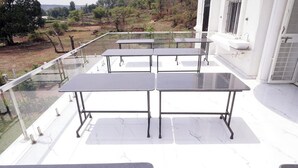A balcony with four tables and a sink. - The Serenity Resort (Mahabaleshwar)