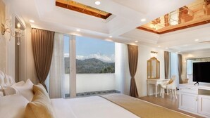A hotel room with a large bed, a desk, a chair, and a TV. - Pokhara Panorama Resort and Spa-Luxury Redefined (Pokhara)