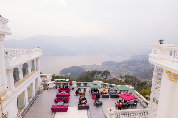 Une terrasse sur le toit, dotée d’un espace extérieur aménagé, offrant une vue sur une vallée et un plan d’eau.