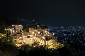 A large, illuminated building with multiple balconies and a spacious courtyard, surrounded by dense city lights. - Pokhara Panorama Resort and Spa-Luxury Redefined (Pokhara)