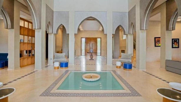 A spacious lobby with a central pool, seating areas, and a reception desk. - Villa Hana B (Marrakech)