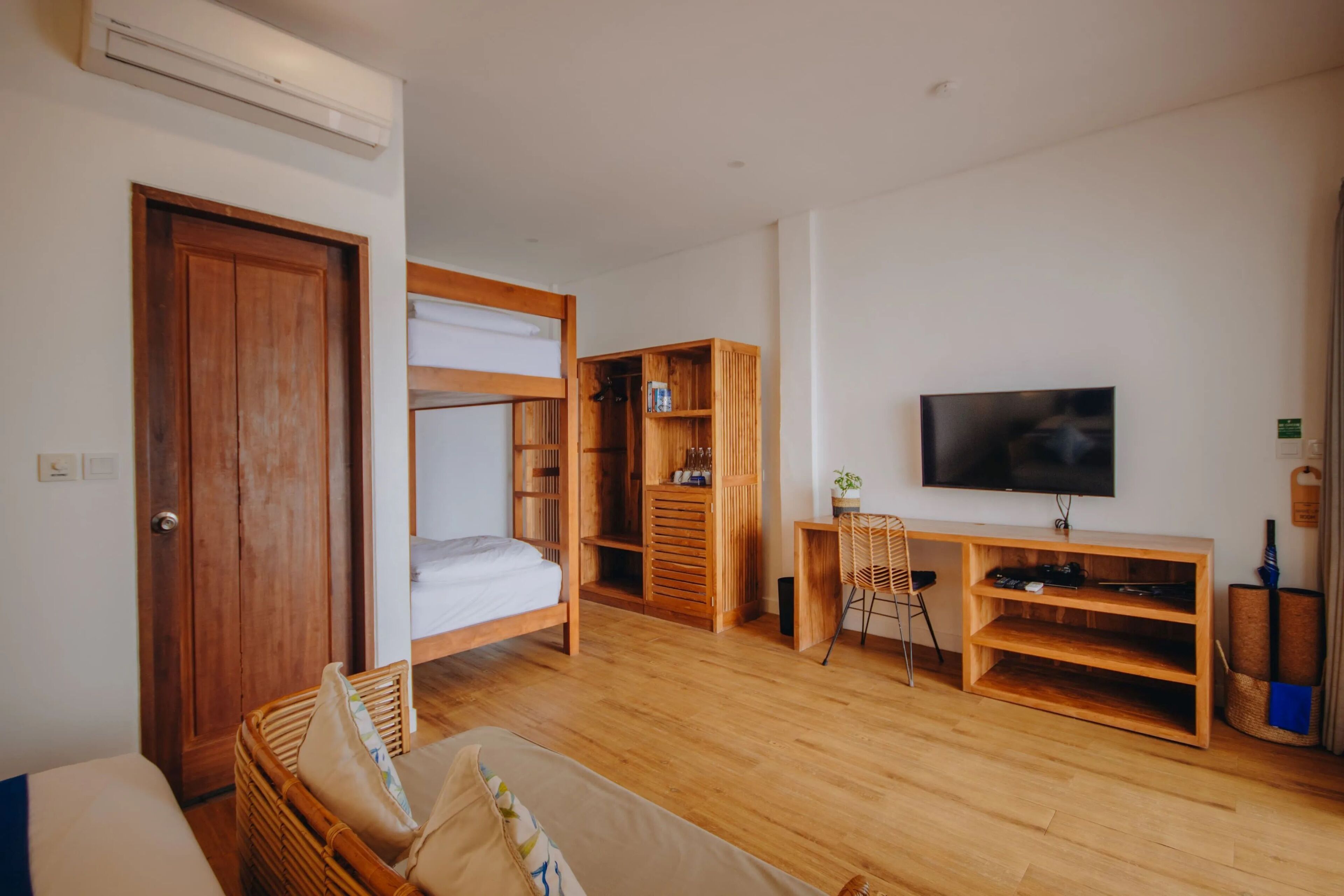 A room with a bed, a desk, a television, and a bookshelf.