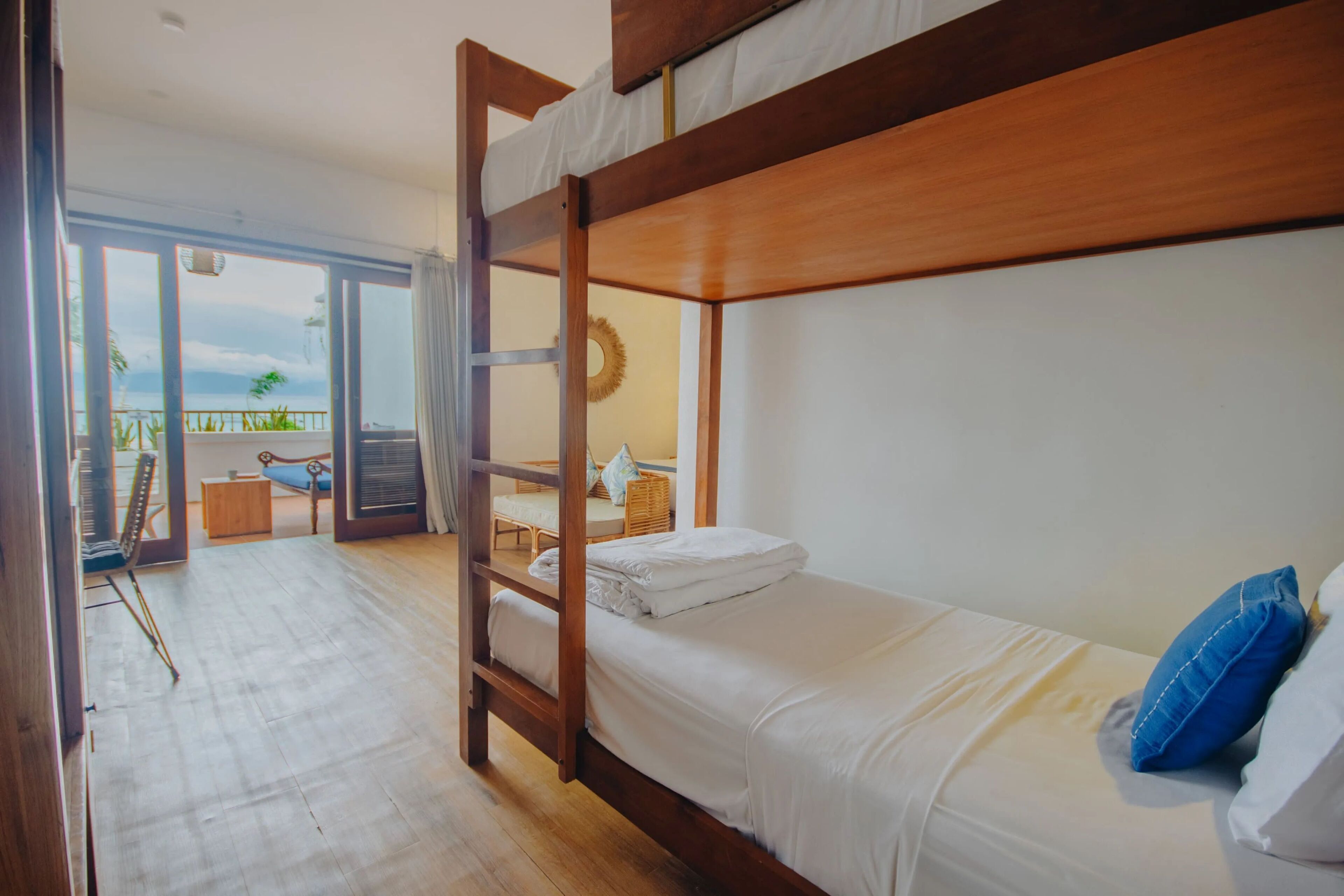 A bunk bed room with a view of the balcony and outdoor area.
