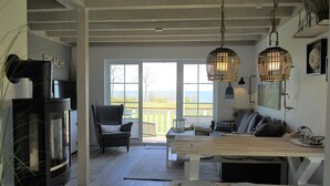 Un amplio espacio de estar con chimenea, una mesa de comedor y un sofá.