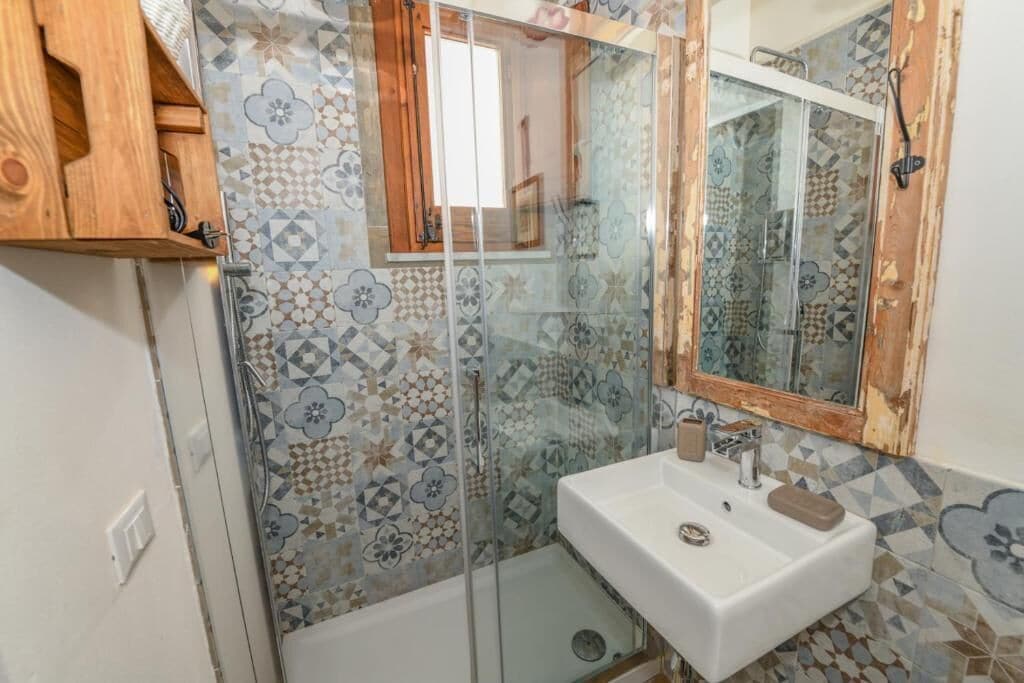 A bathroom with a shower, a sink, and a mirror.