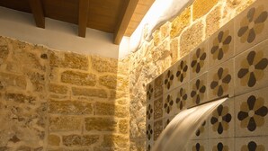 Un espacio de spa con paredes de piedra y una fuente de agua.