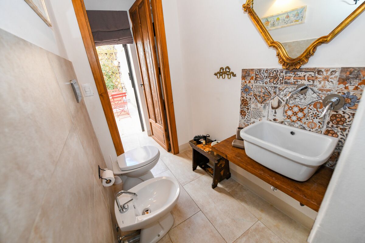 Un baño con lavamanos blanco, un bidé y un espejo.