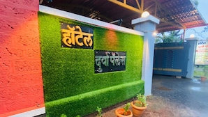 Ein Hotel Eingang mit einer grünen Wand und einem Schild in Hindi.