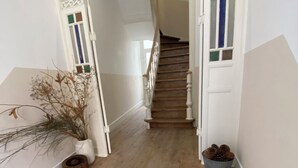 Un escalier en bois avec des rampes blanches et un sol à motifs.