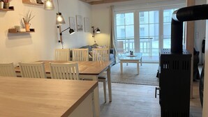 Una cocina moderna con muebles de madera, luces colgantes y un amplio ventanal con vistas a un balcón.