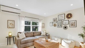 Una sala de estar con sofá, mesa de centro y decoración en la pared.