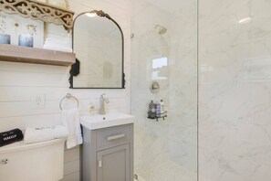 Chuveiro, secador de cabelo, toalhas de banho, shampoo