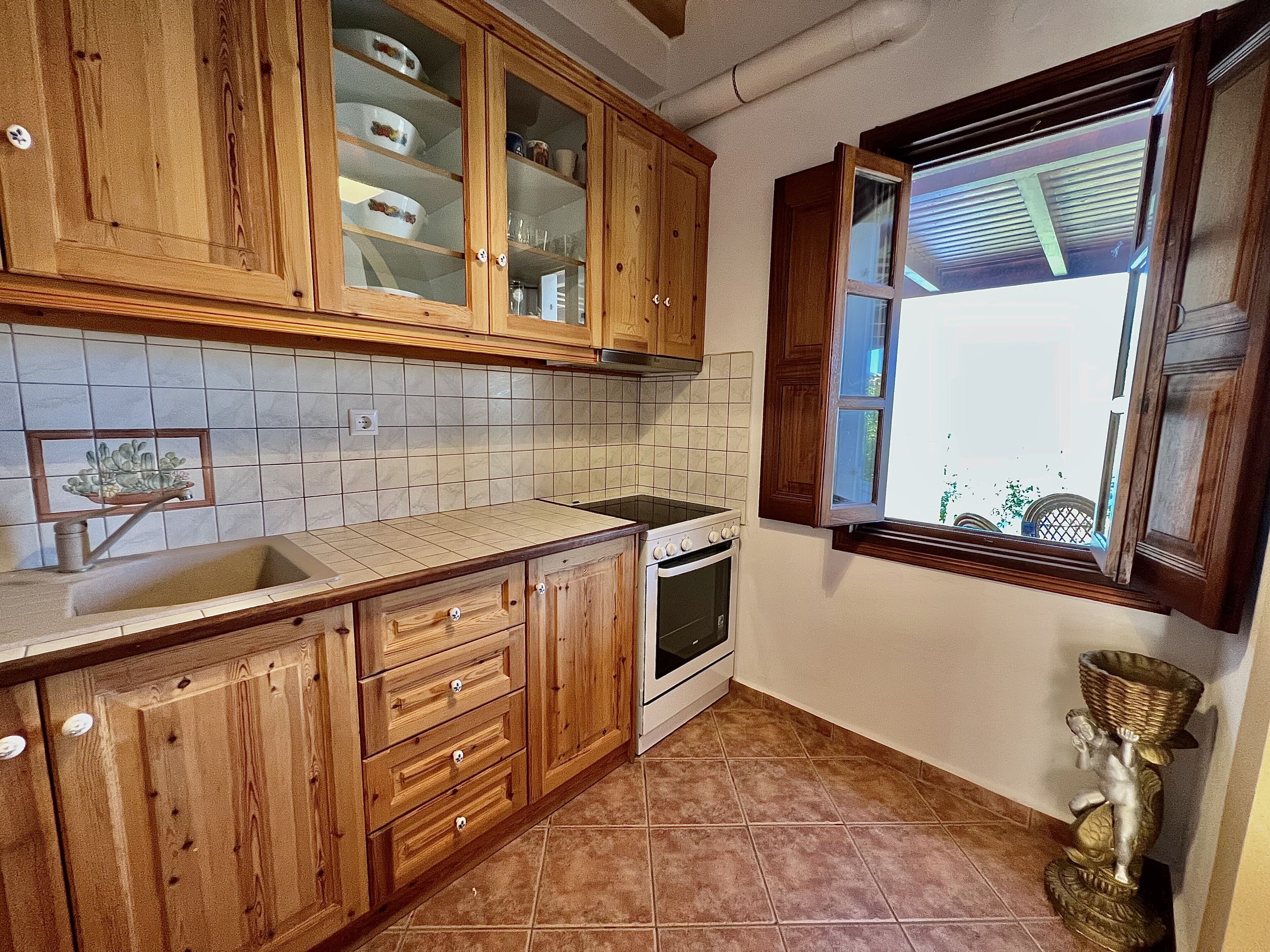 A kitchen with wooden cabinets, a built-in oven, and a window with a view.