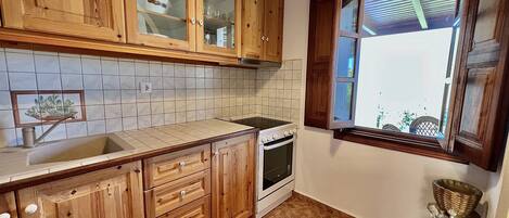 A kitchen with wooden cabinets, a built-in oven, and a window with a view.