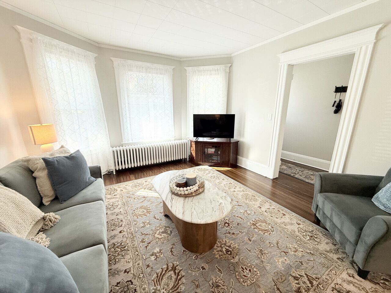 Ein Wohnzimmer mit Sofa, Couchtisch, Fernseher und Heizkörper.