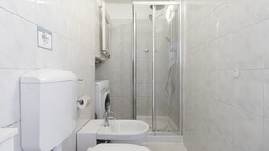 A modern bathroom with a toilet, bidet, and glass-enclosed shower. - Italianway - Meda 43 (Milan)