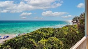 Une plage avec une eau turquoise et limpide, quelques personnes qui se baignent et une vue sur l’océan.