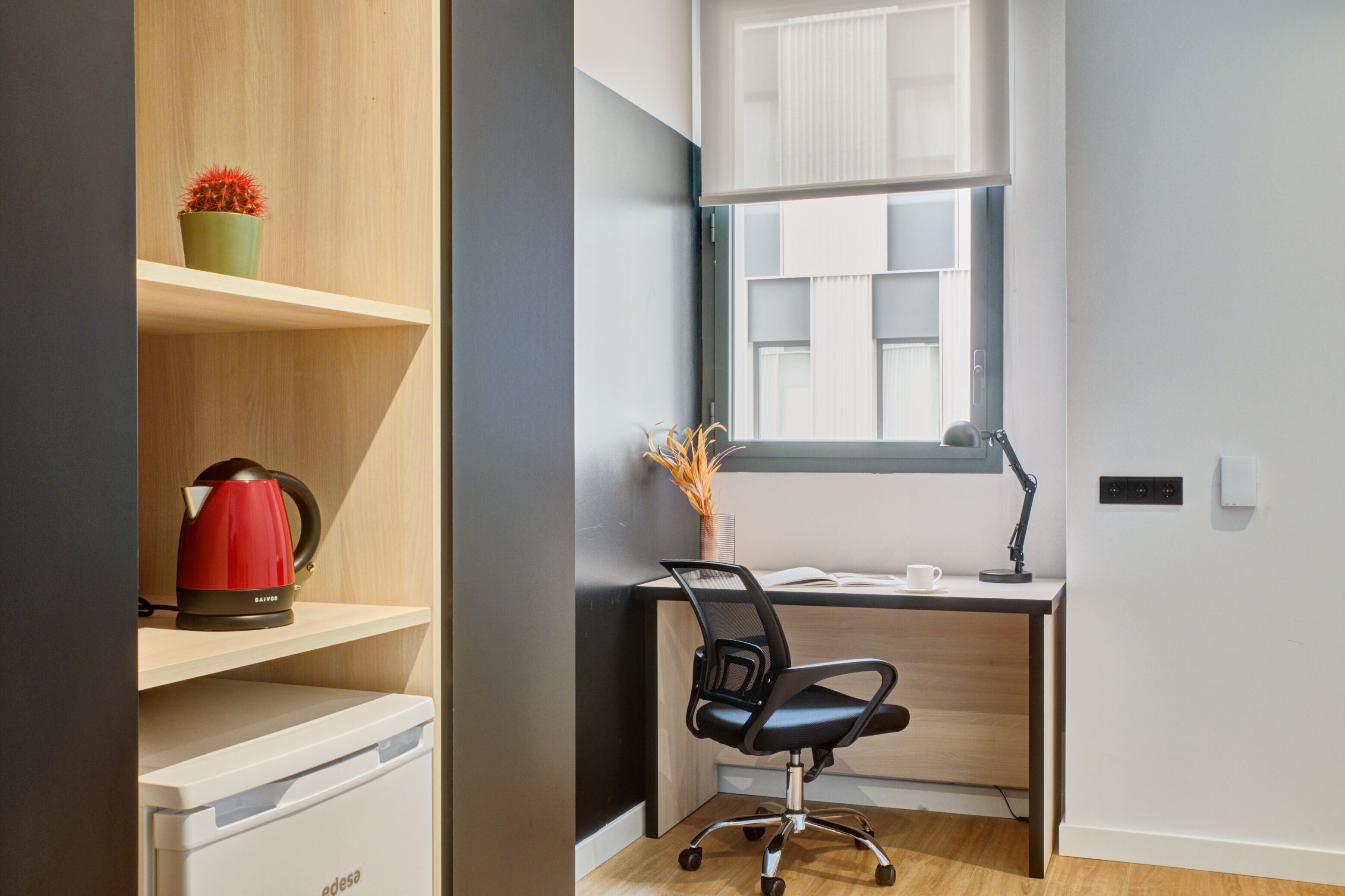 A modern office space with a desk, chair, and shelves.