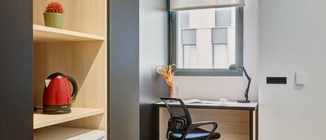 A modern office space with a desk, chair, and shelves.