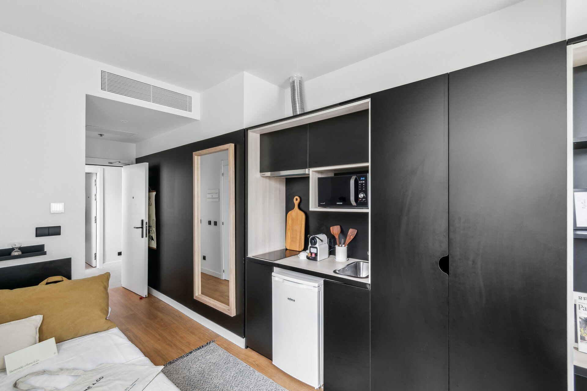 A compact kitchen with a microwave, toaster, and sink.