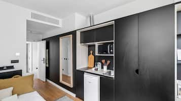 A compact kitchen with a microwave, toaster, and sink.