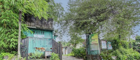 A gated entrance to a property with a sign indicating a 'HOTEL RAKYAT' and a 'RENTAL' option.