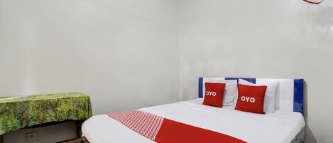 Un dormitorio con cama, mesita de noche y ventilador de techo.