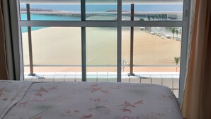 A hotel room with a large window overlooking a beach and the sea. - Terraços DO Atlântico, Frente Mar, Mobiliado, Beira-mar, 19,andar (Praia de Iracema Fortaleza)
