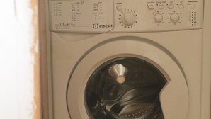 Une machine à laver à chargement frontal, dotée d’un panneau de commande et d’un indicateur de niveau d’eau.