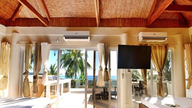 Habitación de hotel con balcón, televisión de pantalla plana y vistas al océano.
