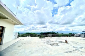 Una terraza en la azotea con vistas al cielo y al paisaje distante.