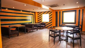 Un restaurante con paredes a rayas, suelo de madera y una combinación de asientos tipo cabina y mesas.