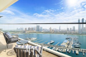 A balcony with a view of a marina and city skyline. - LUX The Marina Vista Beachfront Suite  (Dubai)
