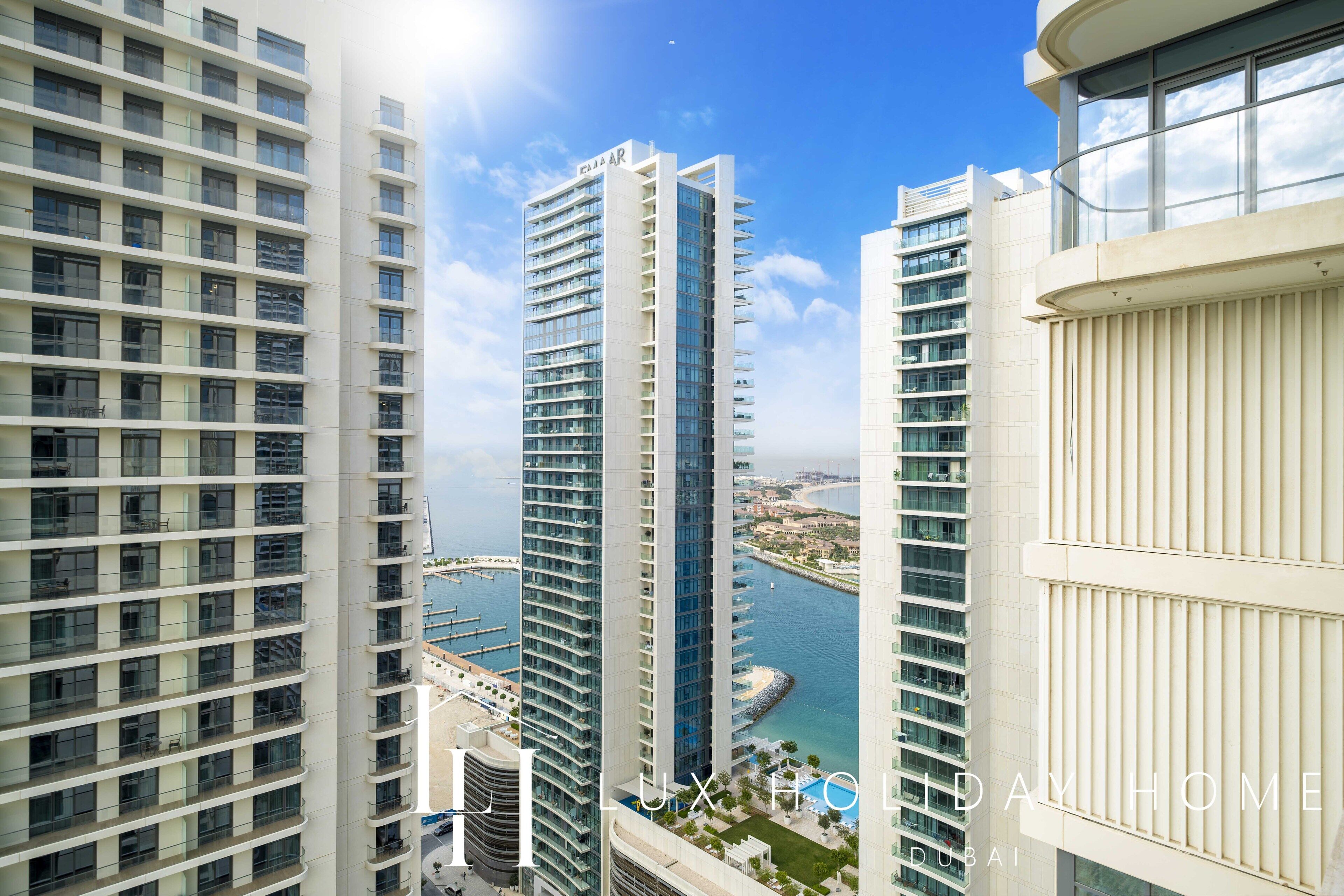 A high-rise building with multiple balconies, a marina in the background, and the text "LUX HOMES DUBAI".