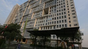 Ein Hochhaus mit zahlreichen Stockwerken, großen Fenstern und einem überdachten Gang.