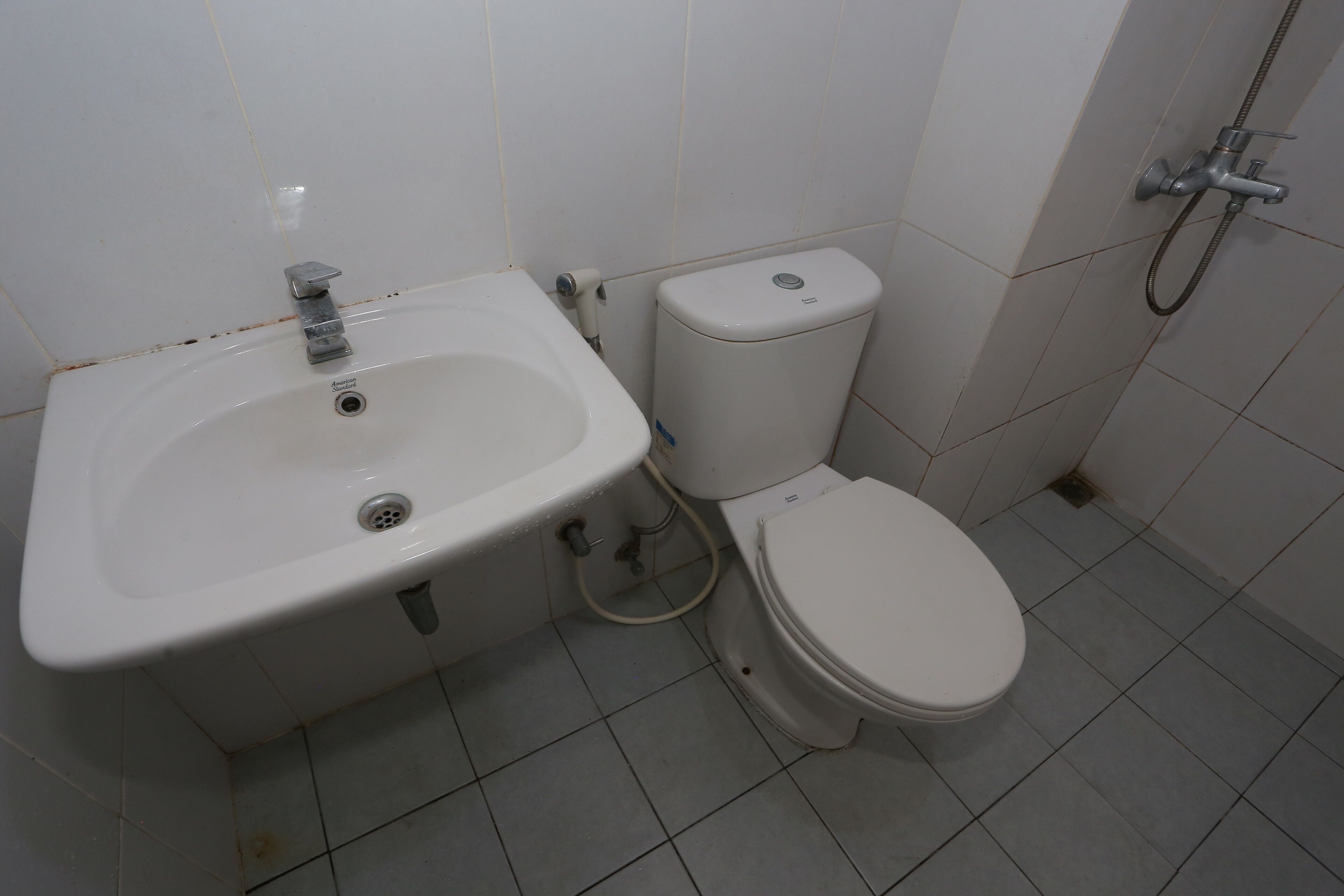 A bathroom with a white sink, toilet, and shower.