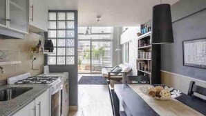 Une cuisine moderne équipée d’une cuisinière à gaz, d’un évier et d’un coin repas avec une table mise pour deux personnes.