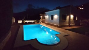 A swimming pool with a unique shape, surrounded by a patio area. - Villa Aucamar- Moraira (TEULADA MORAIRA)