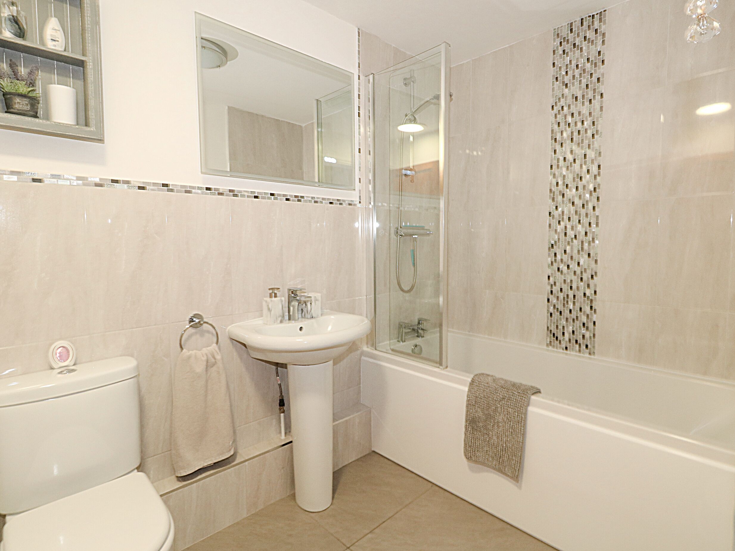 A bathroom with a toilet, sink, and shower.